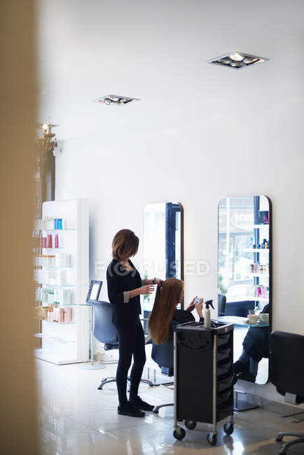 Coiffeur travaillant avec le client dans le salon de coiffure — Photo de stock
