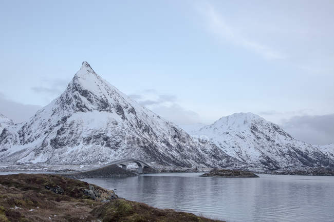Neve coberto montanhas ao longo do lago frio, Lofoten Islands, Noruega — Fotografia de Stock