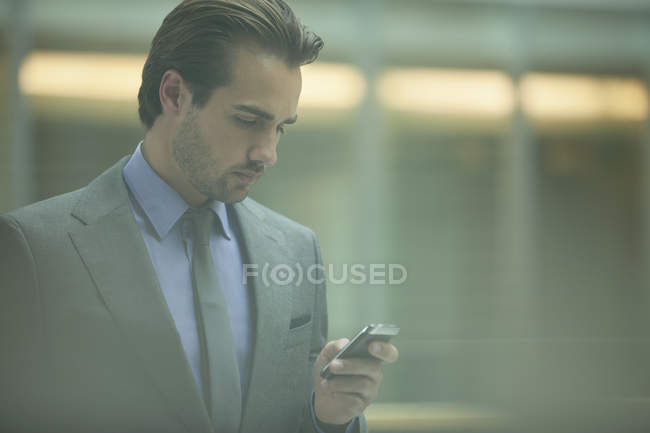 Uomo d'affari che utilizza il cellulare in ufficio — Foto stock