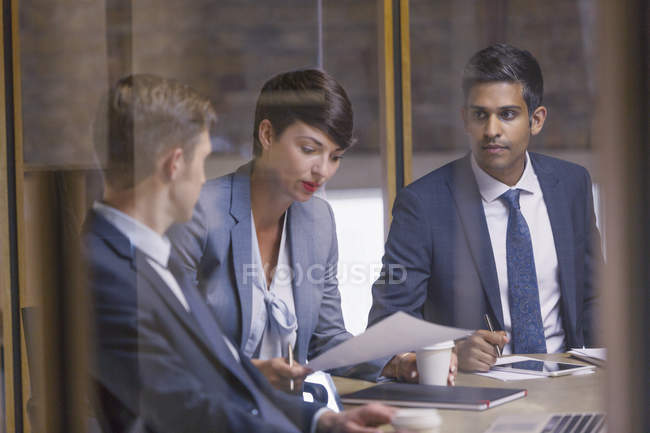 Business people reviewing paperwork in meeting — Stock Photo