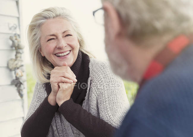 Улыбающаяся пожилая женщина разговаривает с мужчиной — стоковое фото