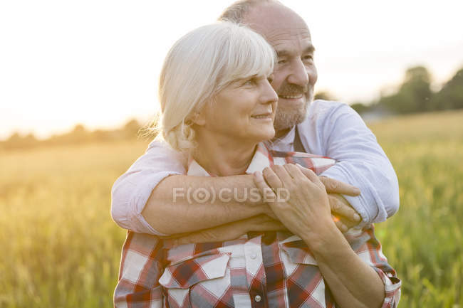 Casal sênior abraçando no campo de trigo rural — Fotografia de Stock