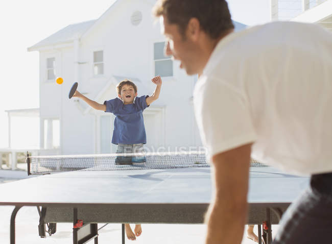 Батько і син грають в настільний теніс на відкритому повітрі — стокове фото
