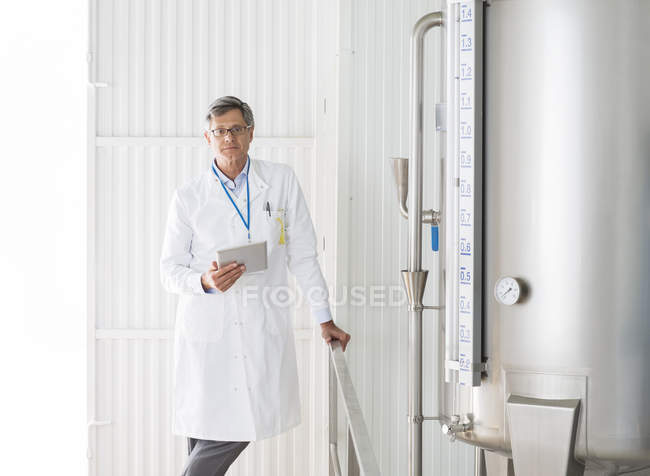 Científico sonriendo en planta de procesamiento de alimentos - foto de stock