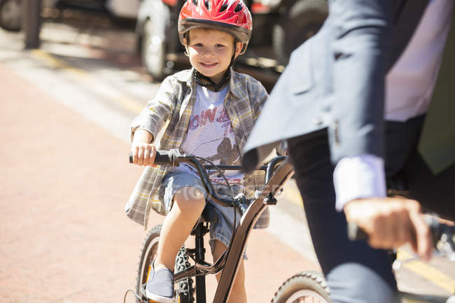 Ritratto ragazzo sorridente in bicicletta su strada soleggiata — Foto stock