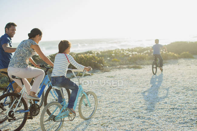 Familie radelt am sonnigen Strand — Stockfoto