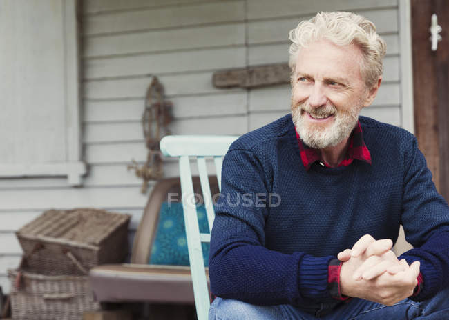 Senior man with hands clasped looking away on patio — Stock Photo
