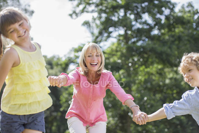 Grandmother and grandchildren playing outdoors together — Stock Photo