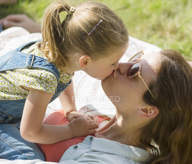 Закрыть рот мать и дочь целуются — стоковое фото