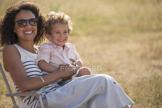 Retrato sorridente mãe e filho em campo ensolarado — Fotografia de Stock