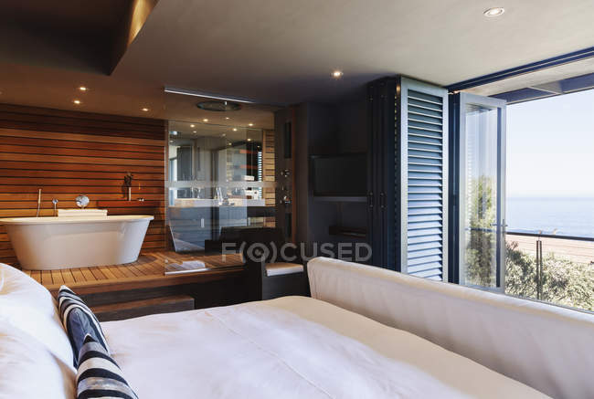 Modern Master Bedroom And Bathroom Overlooking Ocean Soaking Tub Scenic View Stock Photo 199885654