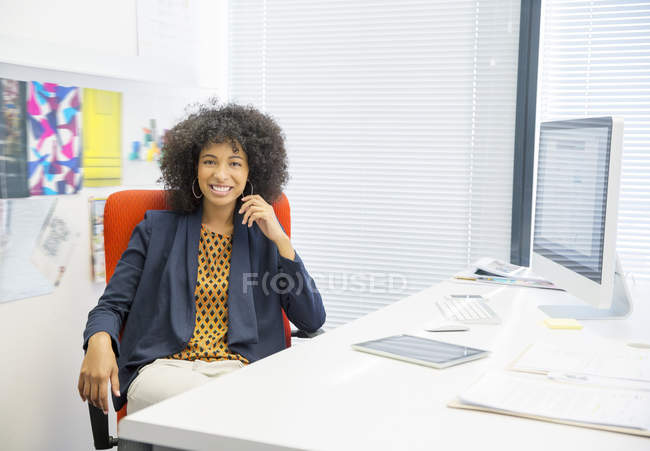 Retrato de una mujer de negocios sonriente en el cargo - foto de stock