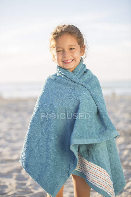 Chica envuelta en toalla en la playa - foto de stock