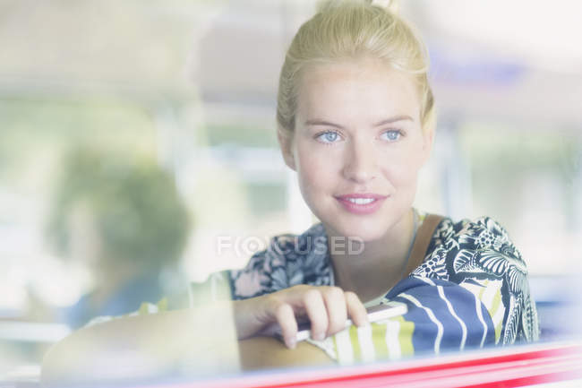 Mulher loira olhando pela janela no ônibus — Fotografia de Stock