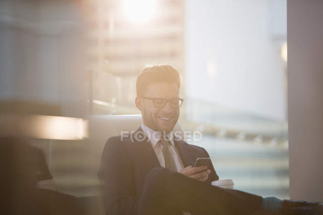 Uomo d'affari che utilizza il cellulare in ufficio — Foto stock