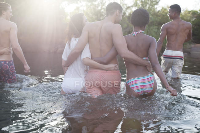 Amici che camminano nel fiume durante il giorno — Foto stock