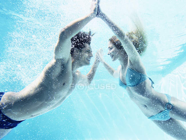 Young attractive couple touching hands underwater — Stock Photo