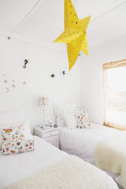 Lámpara estrella amarilla y decoraciones de pared en dormitorio para niños - foto de stock