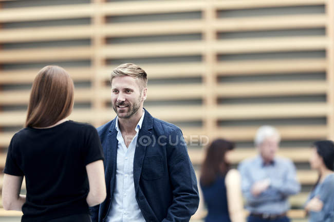 Businessman and businesswoman talking in lobby — Stock Photo