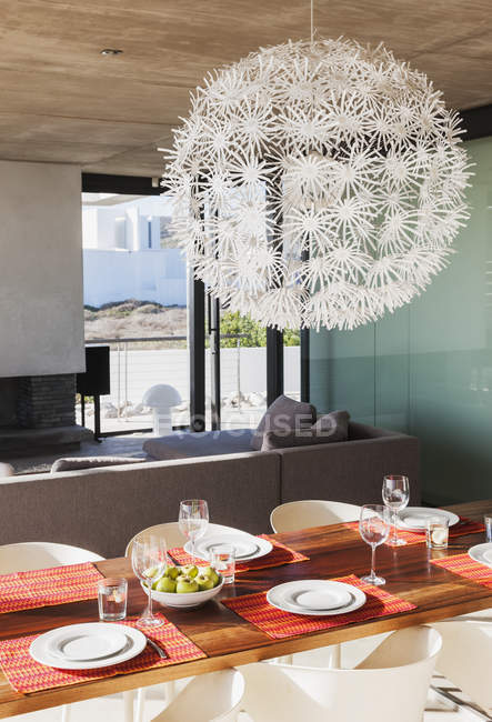 Kronleuchter über gedecktem Esstisch im modernen Speisesaal — Stockfoto