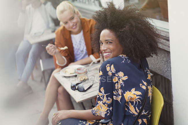 Портрет усміхненої жінки з другом у тротуарному кафе — стокове фото