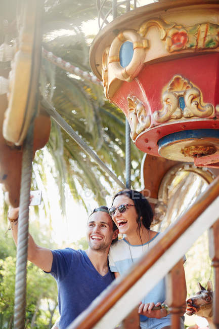 Jeune couple prenant selfie au parc d'attractions — Photo de stock