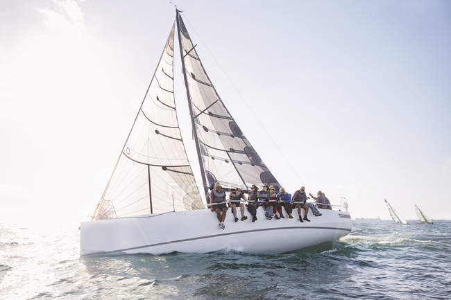 Caucasian senior friends sailing on sunny ocean — Stock Photo