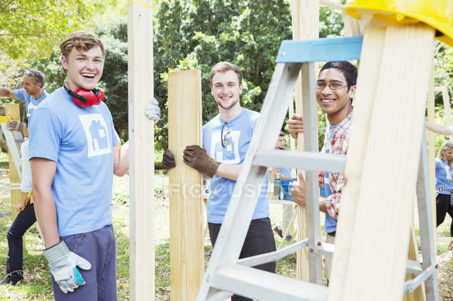 Portrait of smiling volunteers working at construction site — Stock Photo