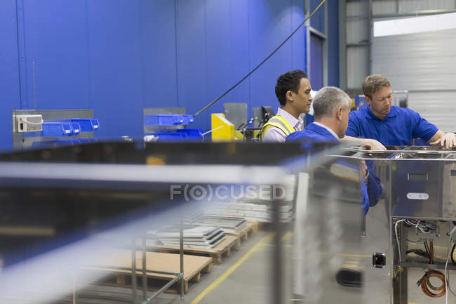 Workers examining equipment in steel factory — Stock Photo