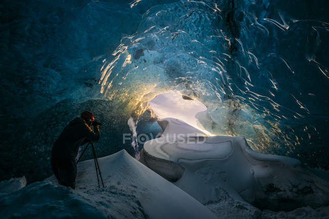 Photographer in ice cave, Iceland — Stock Photo