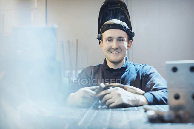 Soldador sonriente de retrato en fábrica de acero - foto de stock