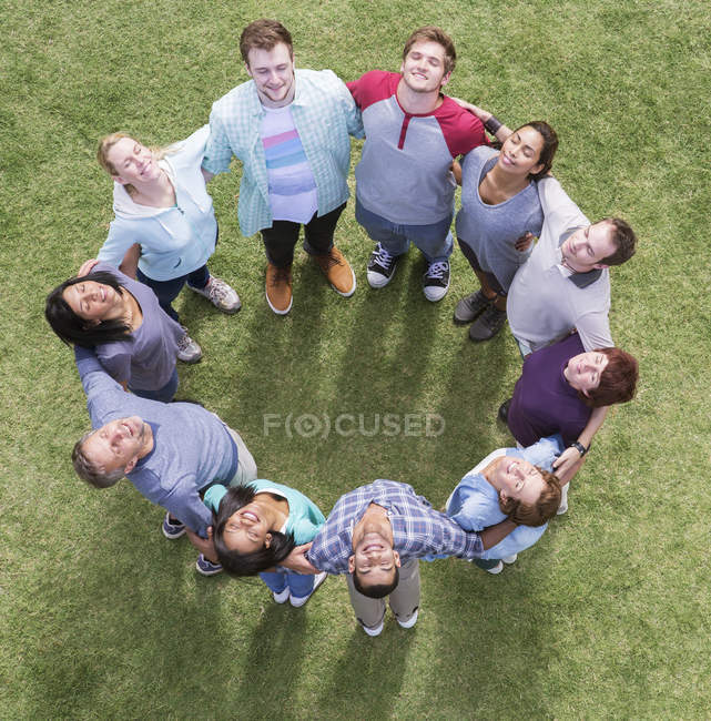 Équipe formant un cercle connecté se prélasser dans un champ ensoleillé — Photo de stock