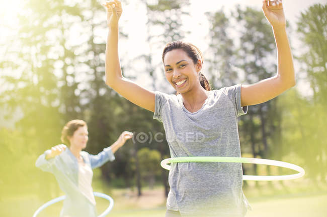 Portrait of smiling woman spinning in plastic hoop — Stock Photo