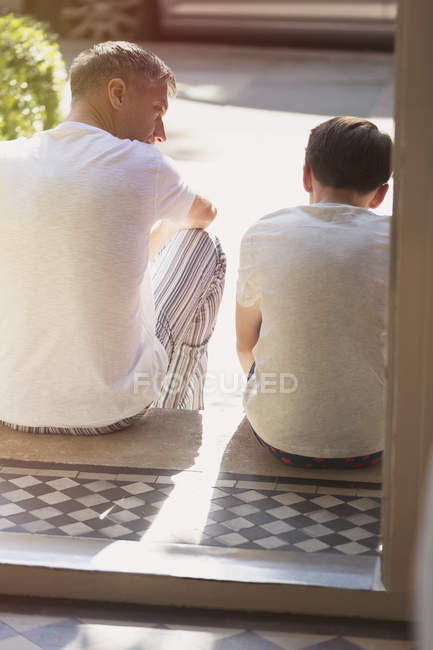 Vista posteriore di padre e figlio che parlano su chinarsi davanti — Foto stock
