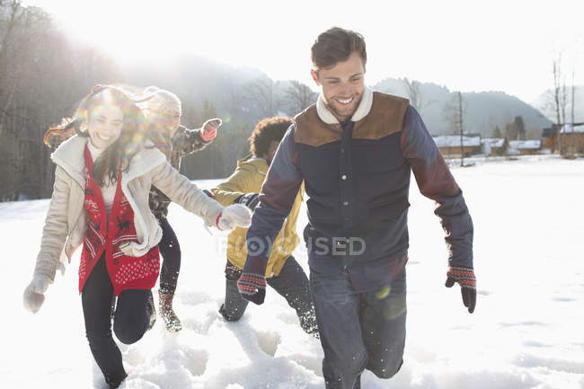 Друзі біжать снігом — стокове фото
