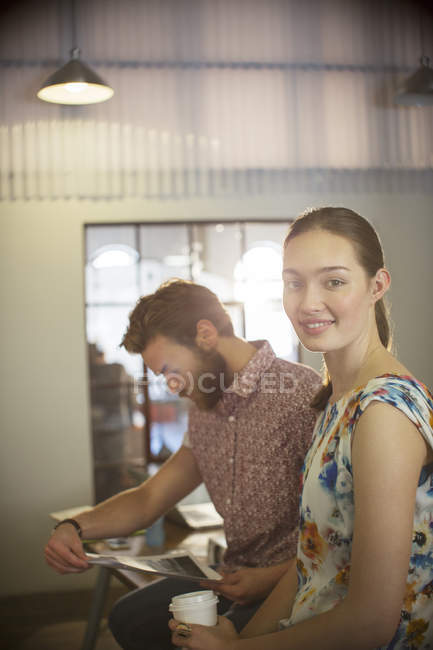 Portrait smiling casual businesswoman reviewing proofs with businessman in office — Stock Photo