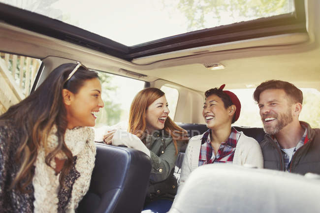 Couples riding and laughing in car — Stock Photo