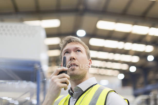 Supervisor using walkie-talkie in steel factory — Stock Photo