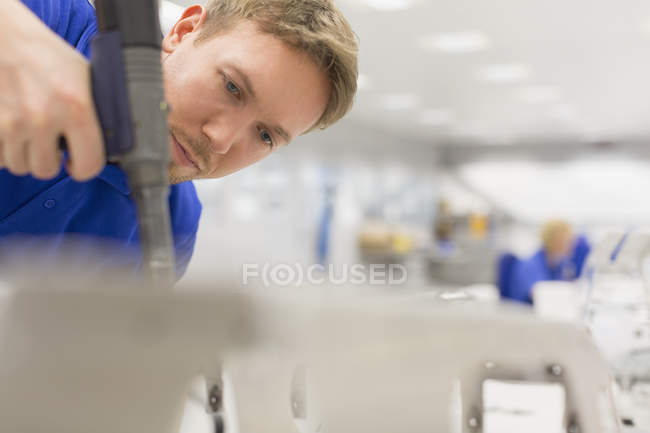 Focused worker using drill in steel factory — Stock Photo