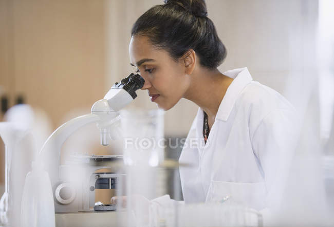 Scienziata che utilizza il microscopio in laboratorio — Foto stock