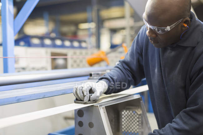 Працівник шліфує сталь на металургійному заводі — стокове фото