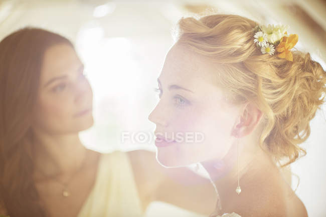 Portrait de mariée avec demoiselle d'honneur en arrière-plan dans la chambre domestique — Photo de stock