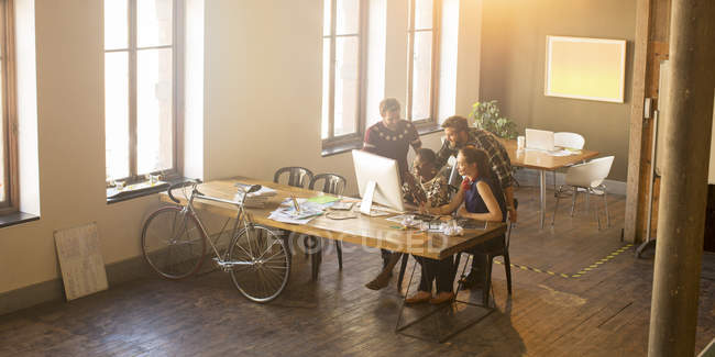 Les gens d'affaires occasionnels se réunissent autour de l'ordinateur dans le bureau — Photo de stock
