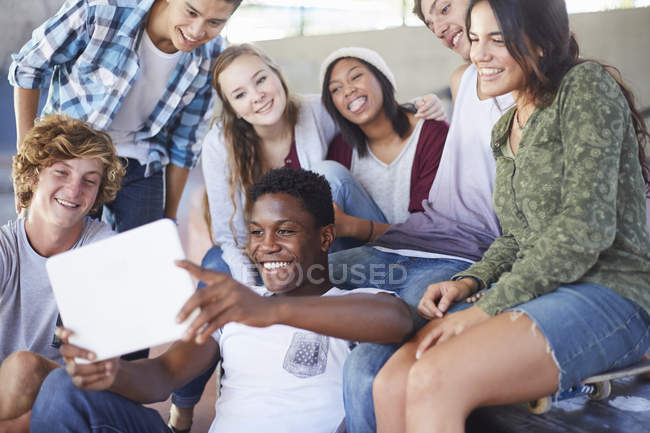 Amigos adolescentes pasando el rato tomando selfie con la tableta digital - foto de stock