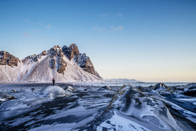 Femme debout parmi un paysage reculé et glacé, Hofn, Islande — Photo de stock