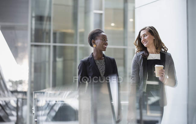 Geschäftsfrauen mit Kaffee reden und gehen — Stockfoto
