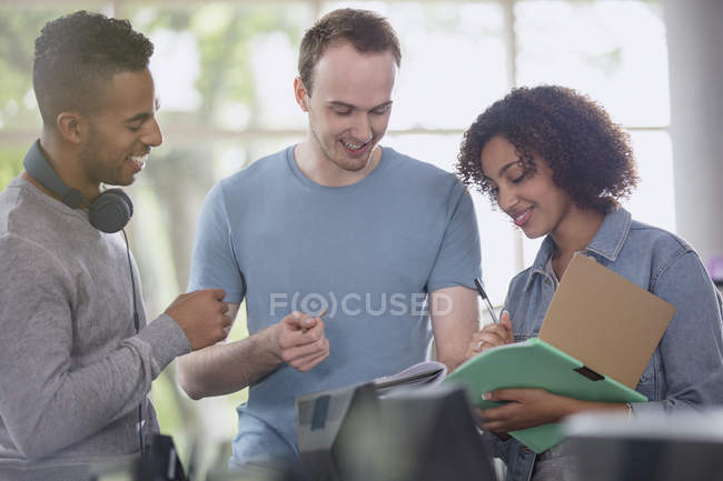 Estudiantes universitarios discutiendo deberes juntos - foto de stock