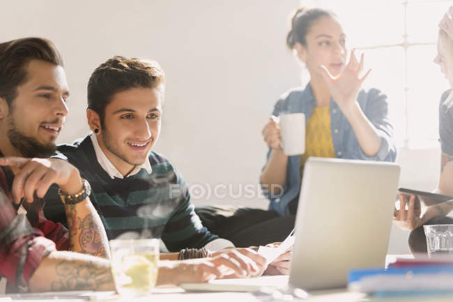 Creative young business people working at laptop — Stock Photo