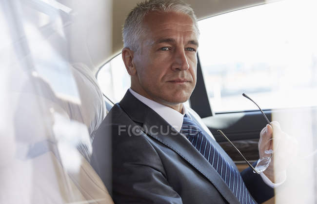 Pensive бізнесмен їде на задньому сидінні міського автомобіля — стокове фото