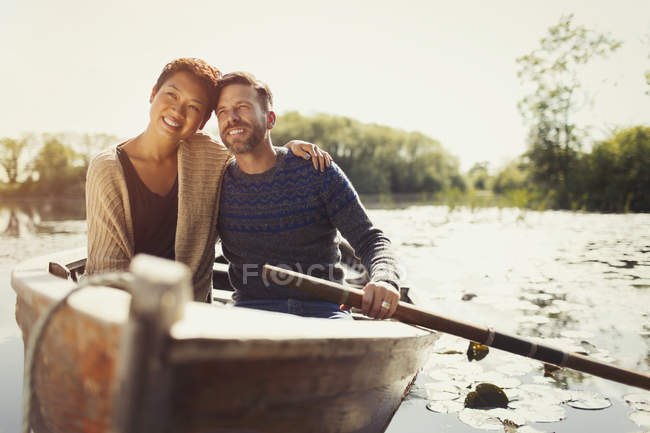 Portrait hugging couple canoeing on sunny lake — Stock Photo